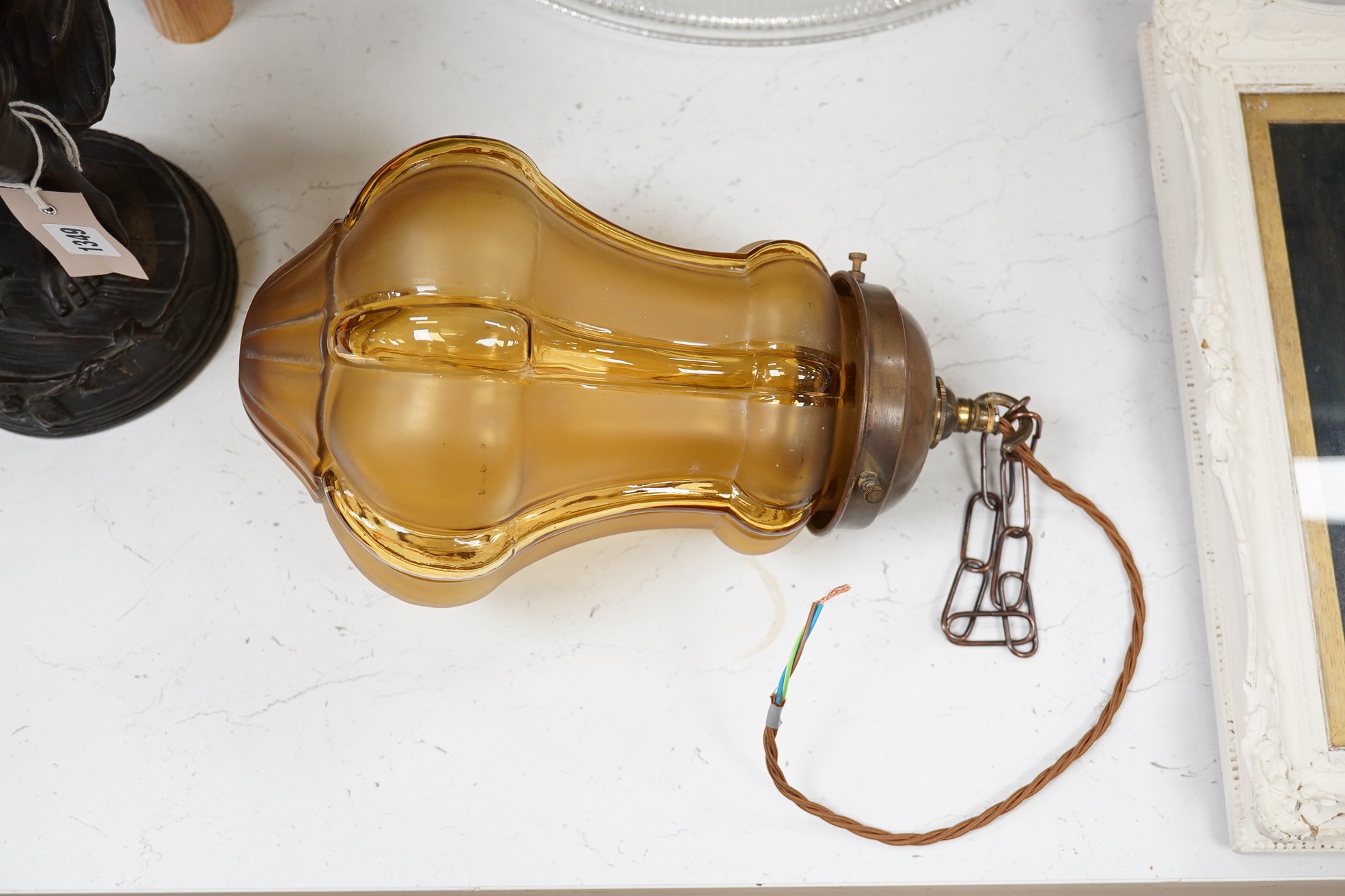 A large English amber colour glass pendant with original antique brass fitting, chain and ceiling rose, circa 1930, wired, 33cm high to top of gallery, 18cm wide. Condition - good